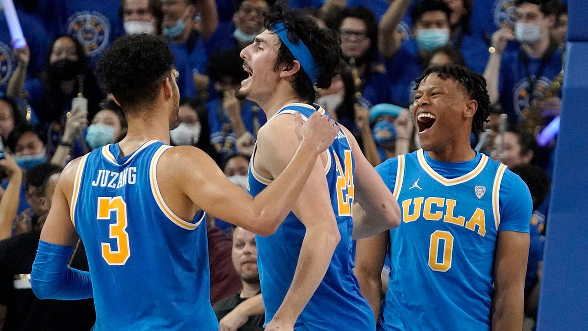 UCLA guard Jaime Jaquez Jr., center, celebrates as time runs out with guard Johnny Juzang, left, and guard Jaylen Clark in second half of an NCAA college basketball game against Southern California Saturday, March 5, 2022, in Los Angeles. UCLA won 75-68.