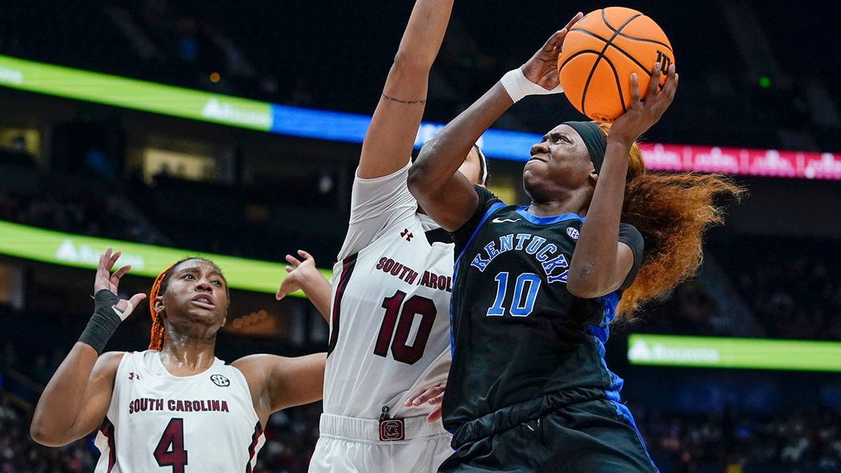 Kentucky's Rhyne Howard, right, drives against South Carolina's Kamilla Cardoso, center, and Aliyah Boston (4) in the first half of the NCAA women's college basketball Southeastern Conference tournament championship game Sunday, March 6, 2022, in Nashville, Tenn.