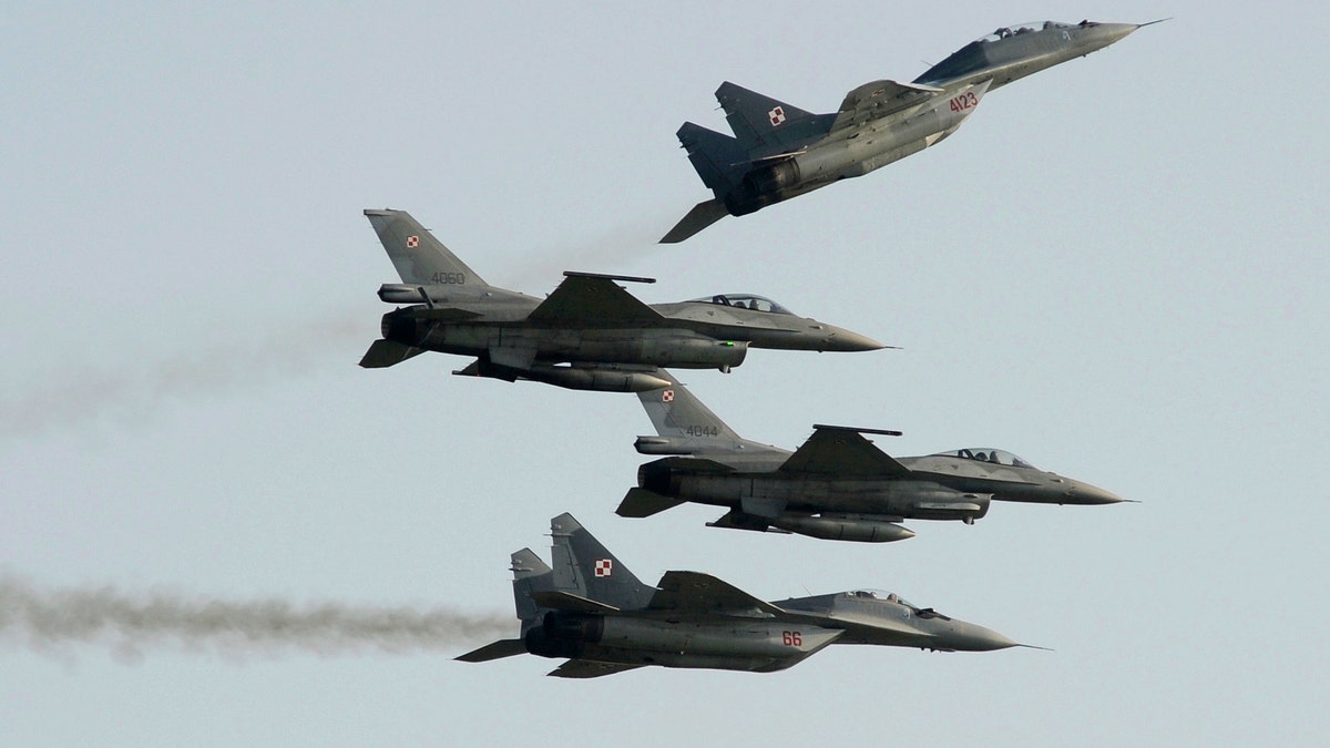 FILE - Two Polish Air Force Russian made Mig 29's fly above and below two Polish Air Force U.S. made F-16's fighter jets during the Air Show in Radom, Poland, on Aug. 27, 2011.?