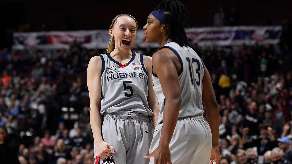 Connecticut's Paige Bueckers (5) reacts toward teammate Christyn Williams in the first half of an NCAA college basketball game against Marquette in the Big East tournament semifinals at Mohegan Sun Arena, Sunday, March 6, 2022, in Uncasville, Conn.