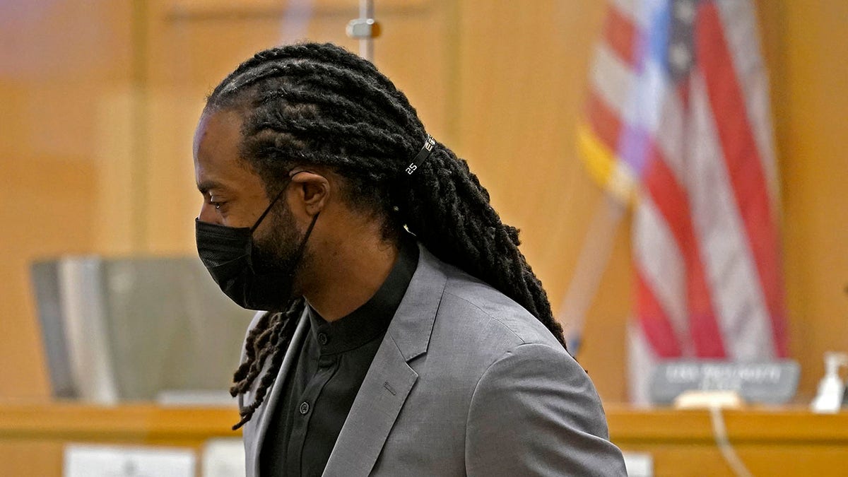 FILE - Richard Sherman stands up to leave a King County District Court hearing, Friday, July 16, 2021, in Seattle. Sherman, now with the Tampa Bay buccaneers, pleaded guilty Monday to two misdemeanor charges stemming from a drunken driving and domestic disturbance last summer as part of an agreement that spares him further jail time.