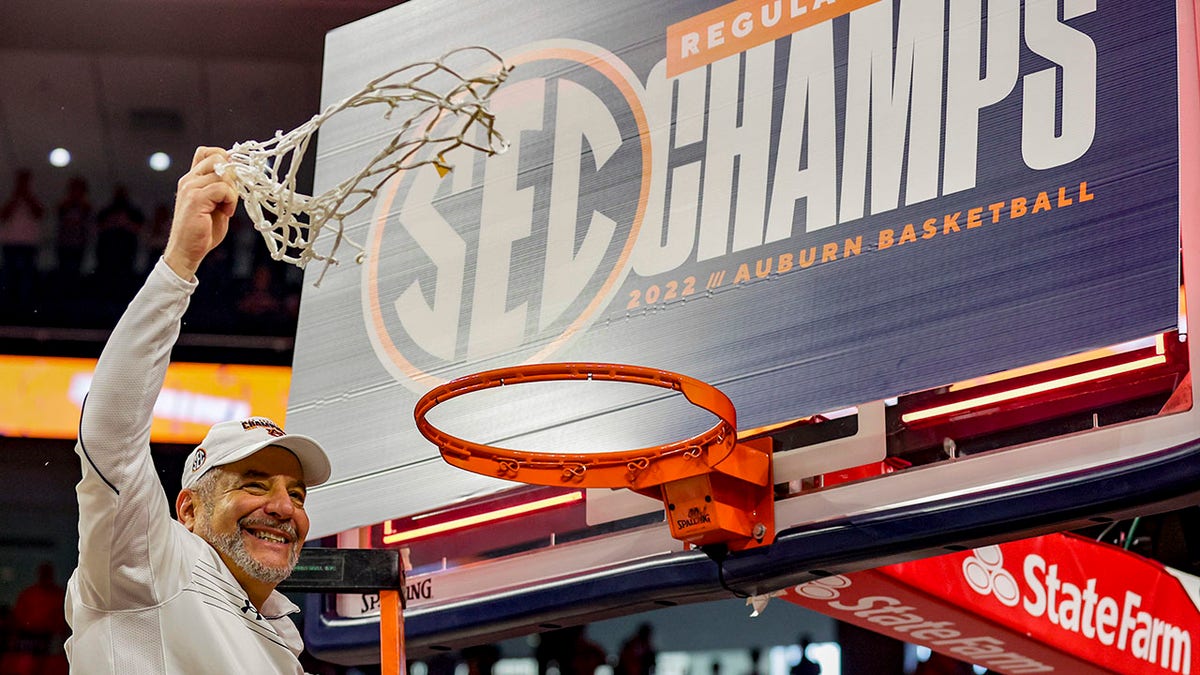 FILE - Auburn head coach Bruce Pearl celebrates the team's Southeastern Conference regular season championship by cutting down the net after an NCAA college basketball game against South Carolina, Saturday, March 5, 2022, in Auburn, Ala. Pearl is the  The Associated Press coach of the year in the Southeastern Conference, announced Tuesday, March 8, 2022.