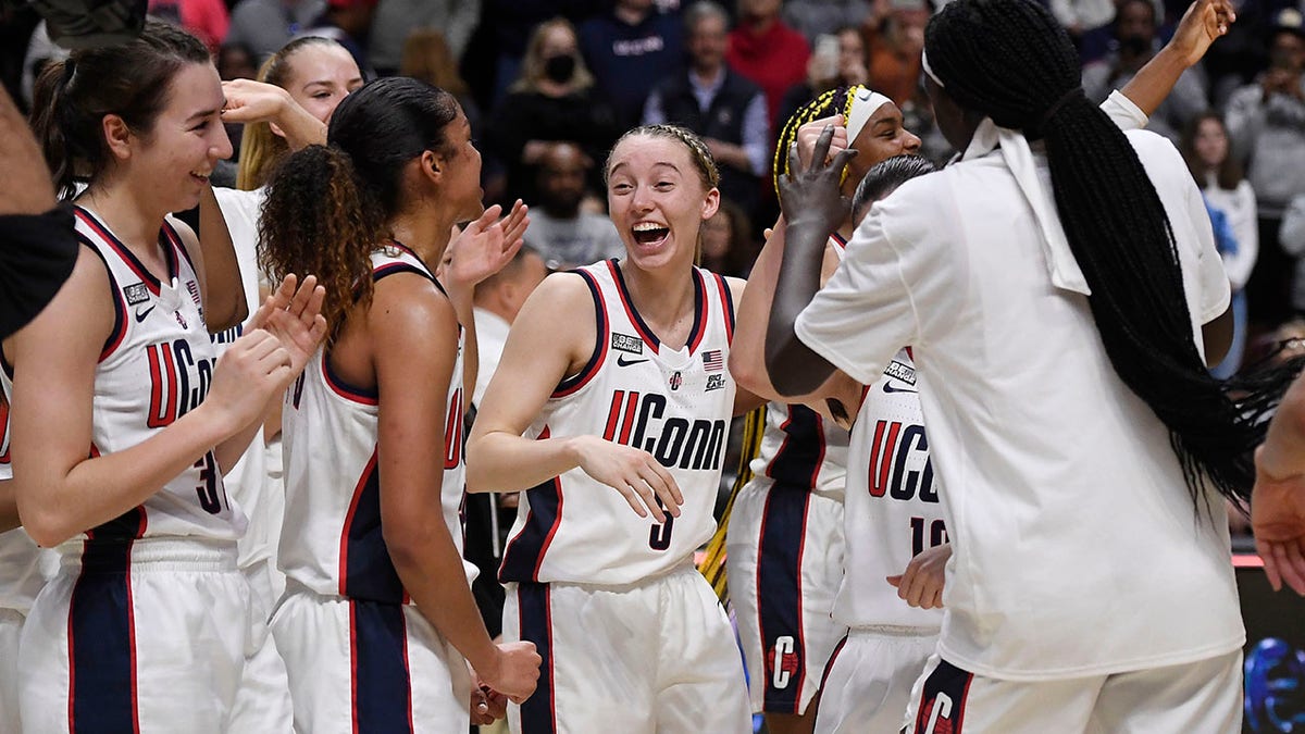 Connecticut's Paige Bueckers (5) and teammates celebrate their win against Villanova in an NCAA college basketball game in the Big East tournament final at Mohegan Sun Arena, Monday, March 7, 2022, in Uncasville, Conn.