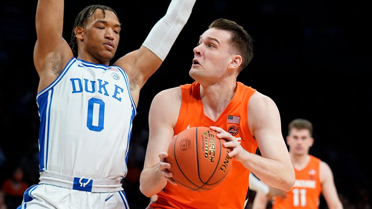 Syracuse's Jimmy Boeheim, right, drives against Duke's Wendell Moore Jr. (0) in the first half of an NCAA college basketball game during quarterfinals of the Atlantic Coast Conference men's tournament, Thursday, March 10, 2022, in New York.