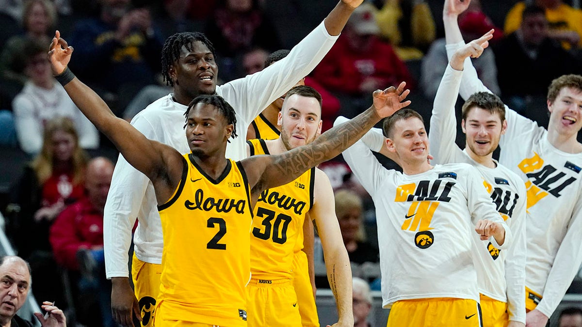 Iowa guard Joe Toussaint (2) and the Iowa bench celebrate in the first half of an NCAA college basketball game against Northwestern at the Big Ten Conference tournament in Indianapolis, Thursday, March 10, 2022.