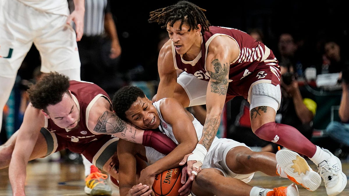Miami's Charlie Moore, center, Boston College's Jaeden Zackery, left, and Makai Ashton-Langford, right, battle for the ball in the first half of an NCAA college basketball game during quarterfinals of the Atlantic Coast Conference tournament, Thursday, March 10, 2022, in New York.