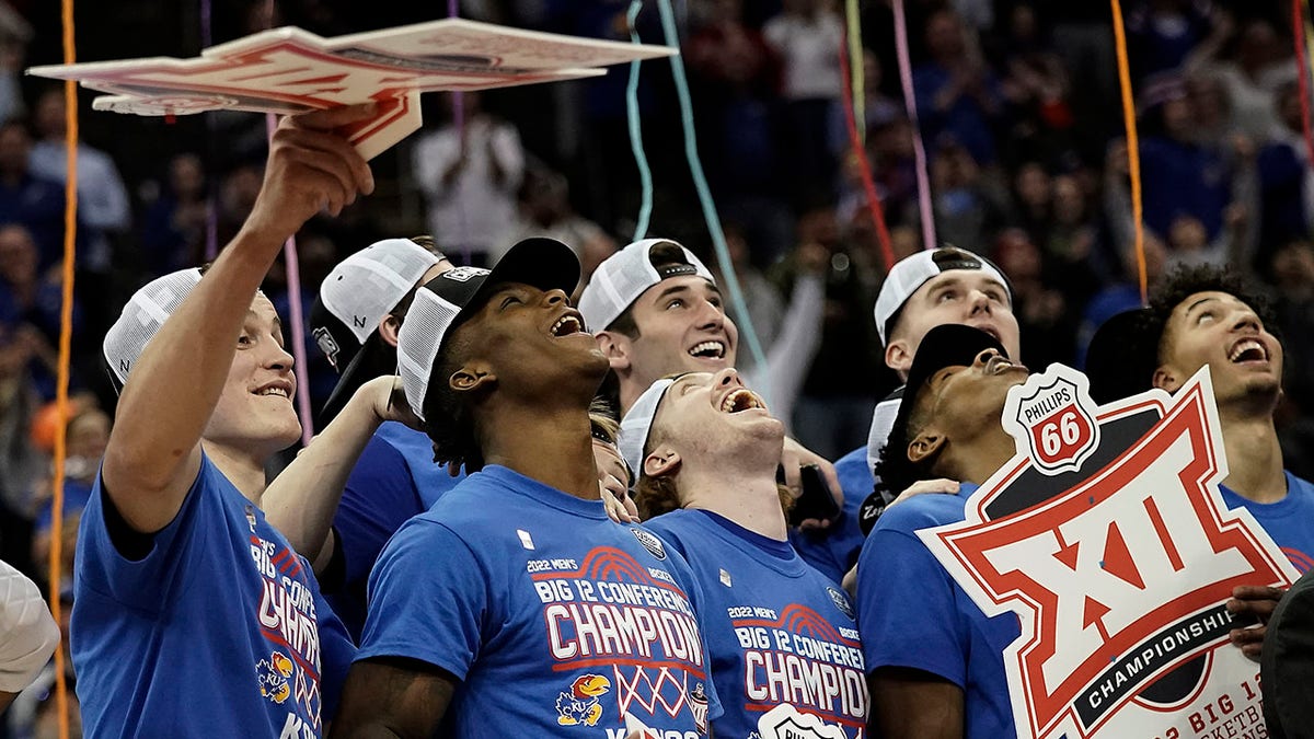 Kansas players celebrate after their NCAA college basketball championship game against Texas Tech in the Big 12 Conference tournament in Kansas City, Mo., Saturday, March 12, 2022. Kansas won 74-65.