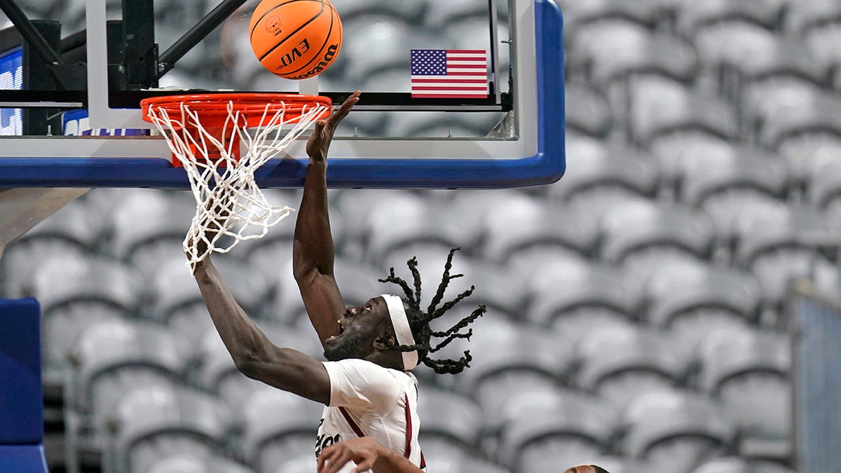 New Mexico State forward Yuat Alok, left, goes to the basket as Abilene Christian guard Damien Daniels defends during the first half of an NCAA college basketball game for the championship of Western Athletic Conference men's tournament Saturday, March 12, 2022, in Las Vegas.