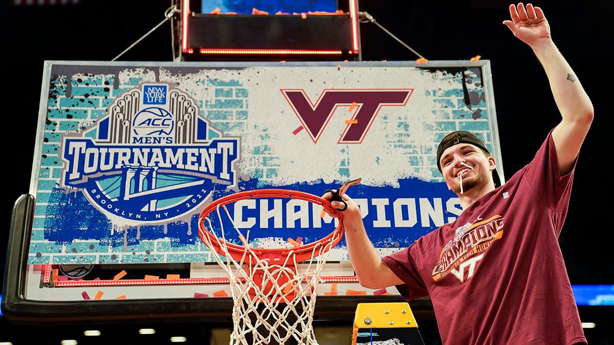 Virginia Tech's Hunter Cattoor, tournament most valuable player, celebrates with a piece of the game net after winning the NCAA college basketball championship game against Duke in the Atlantic Coast Conference men's tournament, Saturday, March 12, 2022, in New York. Virginia Tech won, 82-67.