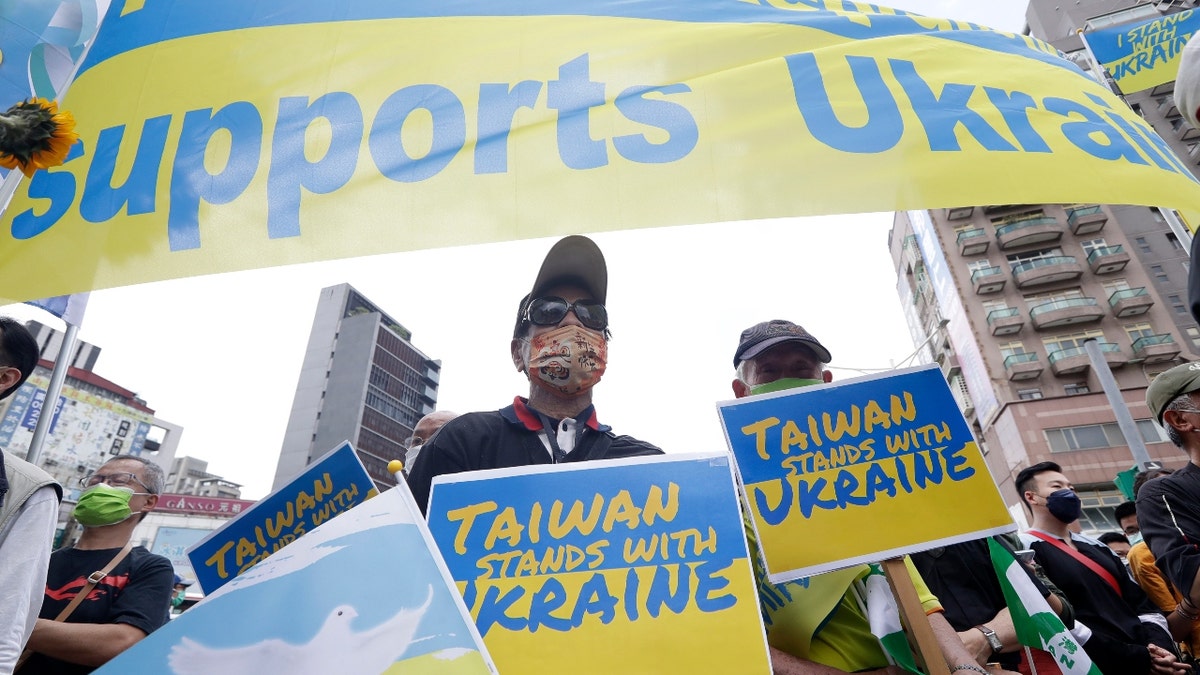 Ukrainian people in Taiwan and supporters hold posters to protest against the invasion of Russia in solidarity with the Ukrainian people during a march in Taipei, Taiwan, Sunday, March 13, 2022. (AP Photo/Chiang Ying-ying)
