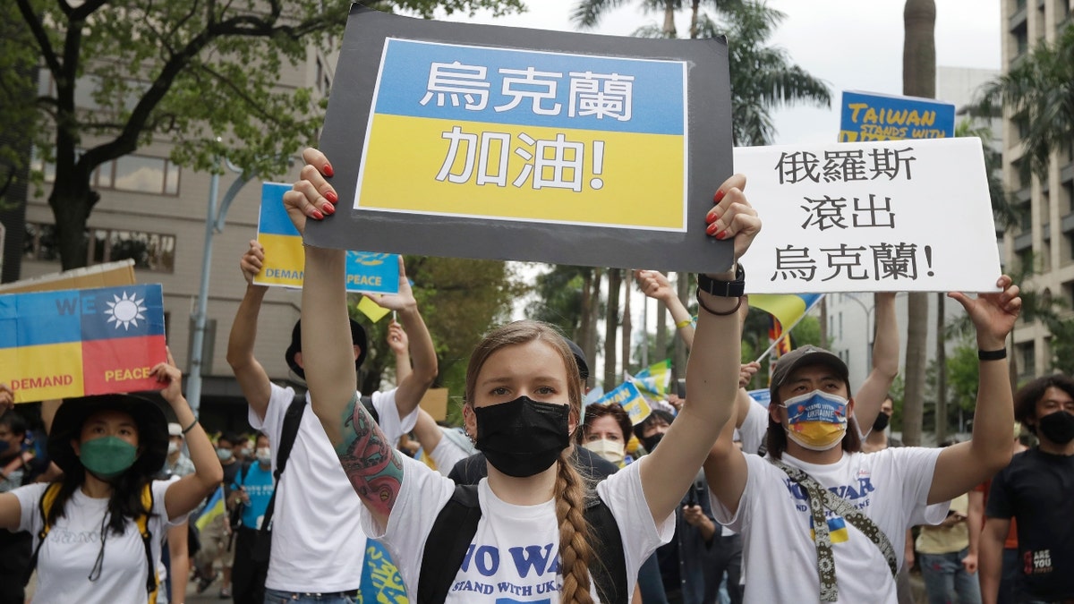 Ukrainian people in Taiwan and supporters hold posters to protest against the invasion of Russia in solidarity with the Ukrainian people during a march in Taipei, Taiwan, Sunday, March 13, 2022. (AP Photo/Chiang Ying-ying)