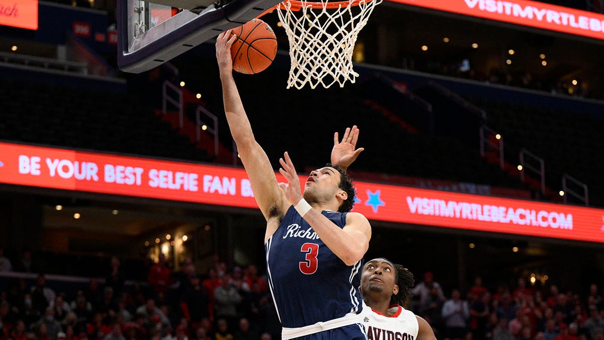 Richmond forward Tyler Burton (3) goes to the basket past Richmond forward Nathan Cayo (4) during the first half of an NCAA college basketball game in the championship of the Atlantic 10 conference tournament, Sunday, March 13, 2022, in Washington.