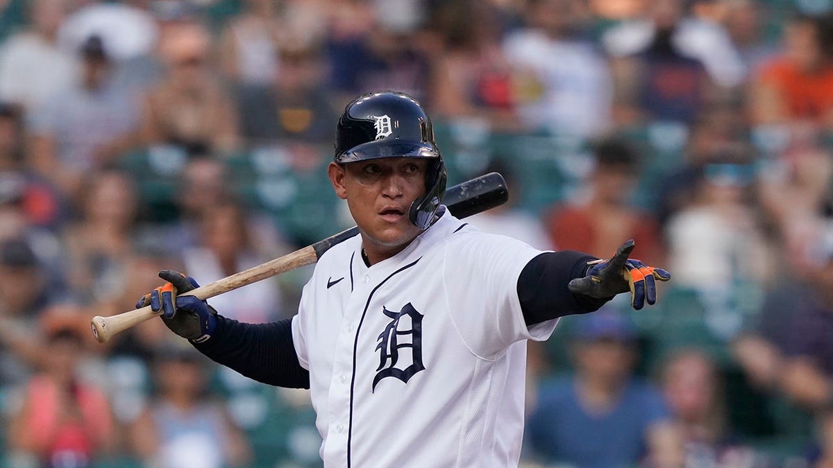 Miguel Cabrera points while holding a baseball bat