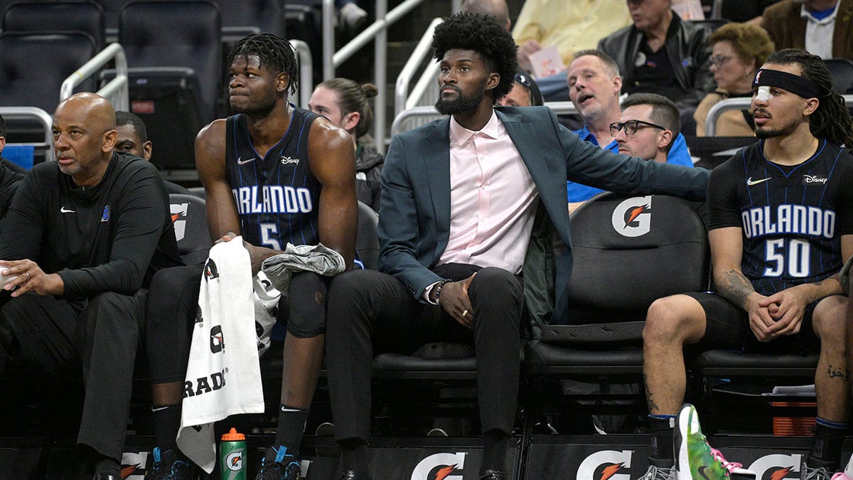 FILE - Orlando Magic forward Jonathan Isaac watches from the bench between center Mo Bamba (5) and guard Cole Anthony (50) during the first half of an NBA basketball game against the Philadelphia 76ers, Sunday, March 13, 2022, in Orlando, Fla. The Orlando Magic announced Tuesday, March 15, 2022, that Jonathan Isaac, who has missed the last two years with a knee injury, will not return this season.
