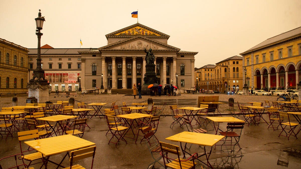 Over the Max-Joseph-Platz and the Staatsoper bad weather with Sahara dust is coming up that colors the sky yellow/orange in Munich, Germany.