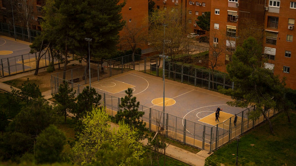 People play basketball in a basketball court covered with dust as storm Celia blew sand from the Sahara desert at the the Cerro del Tio Pio park in Madrid, Spain.
