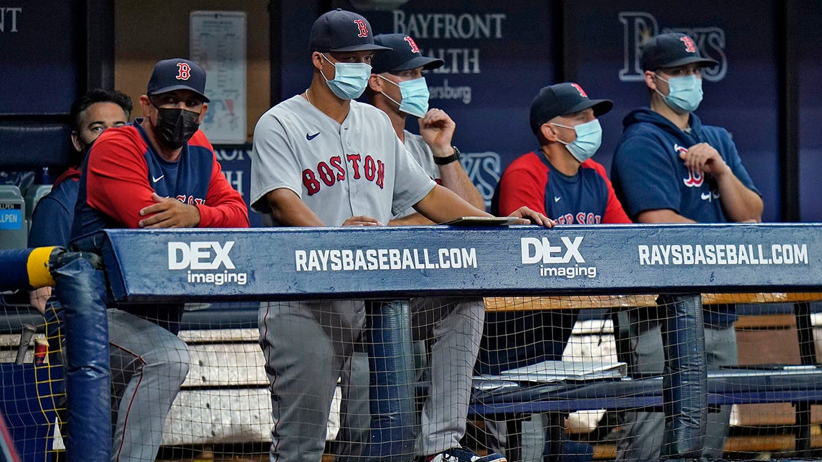 Boston Red Sox manager Alex Cora, left, and other members of the coaching staff wear protective masks during the fourth inning of a baseball game against the Tampa Bay Rays on Monday, Aug. 30, 2021, in St. Petersburg, Fla.