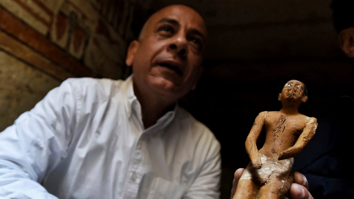 Mostafa Waziri, Secretary General of the Supreme Council of Antiquities, displays a statue found in a recently discovered tomb near the famed Step Pyramid, in Saqqara, south of Cairo, Egypt, Saturday, March 19, 2022.