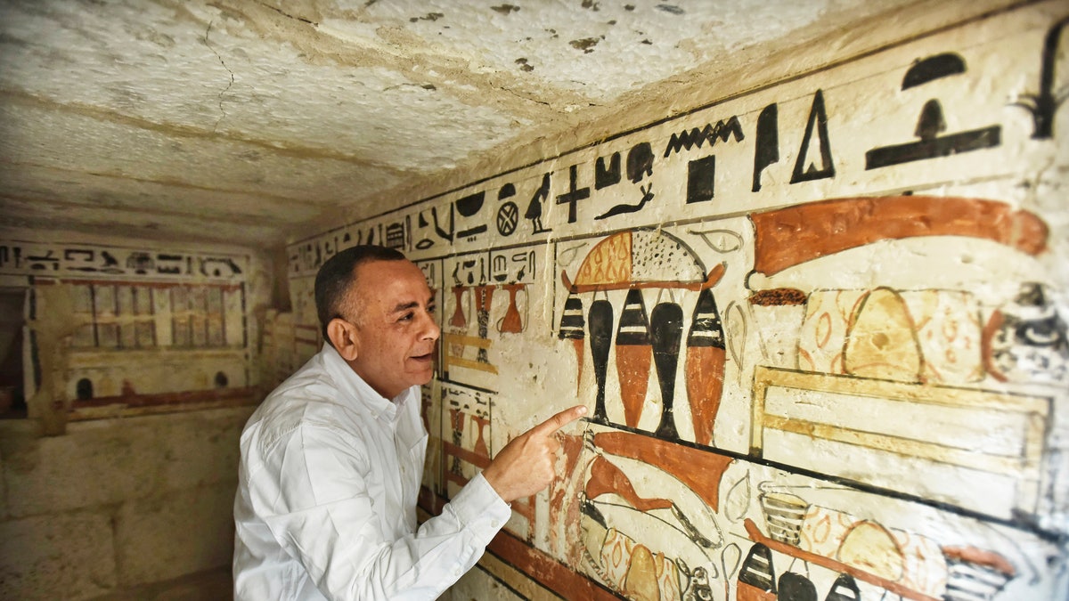 Mostafa Waziri, Secretary General of the Supreme Council of Antiquities, views hieroglyphics inside a recently discovered tomb near the famed Step Pyramid, in Saqqara, south of Cairo, Egypt, Saturday, March 19, 2022.