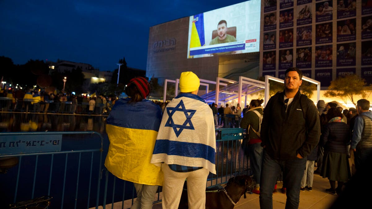 People gather in Habima Square in Tel Aviv, Israel, to watch Ukrainian President Volodymyr Zelenskyy in a video address to the Knesset, Israel's parliament.
