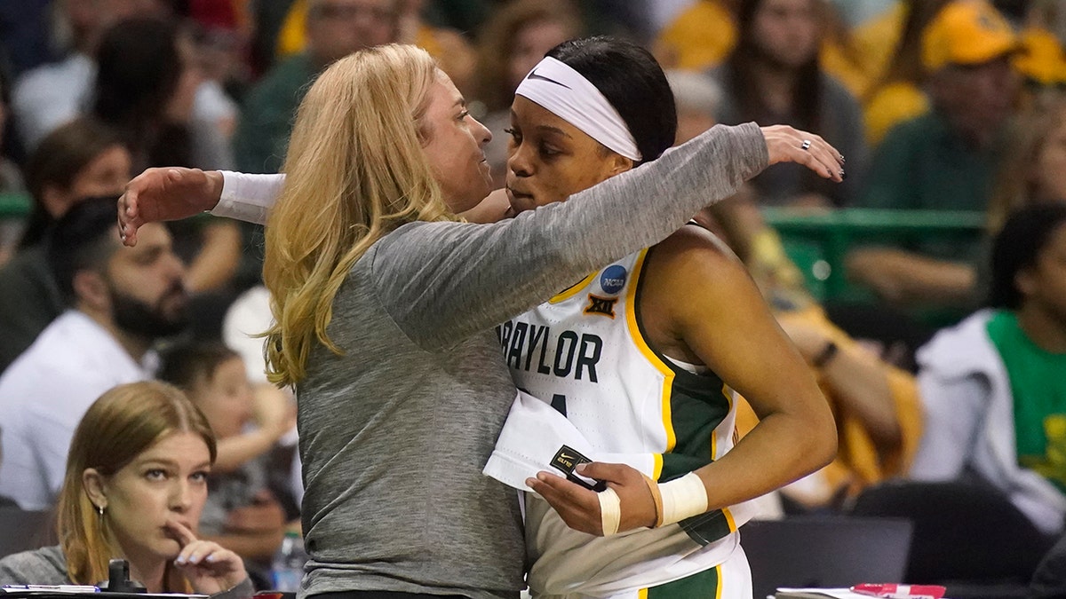 Baylor guard Sarah Andrews, right, gets a hug from head coach Nicki Collen after Andrews fouled out in the final minutes of the second half of a college basketball game against South Dakota in the second round of the NCAA tournament in Waco, Texas, Sunday, March 20, 2022.
