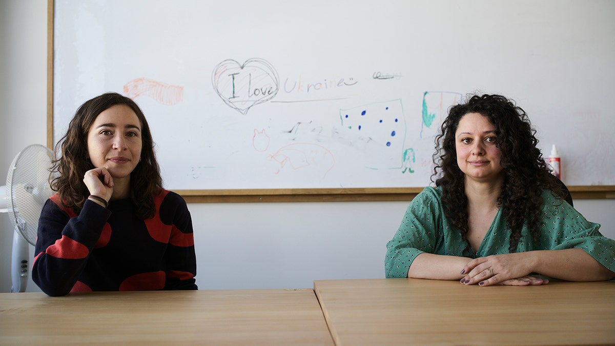 Volunteers Burcak Sevilgen, right, and Faina Karlitski pose for a photo at a space where they organized two school classes for Ukrainian refugees in Berlin, Germany, Monday, March 21, 2022.