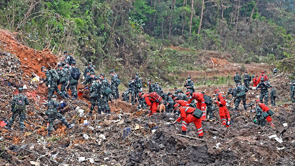 In this photo released by Xinhua News Agency, rescue workers search for the black boxes at a plane crash site in Tengxian county, southwestern China's Guangxi Zhuang Autonomous Region, Tuesday, March 22, 2022.