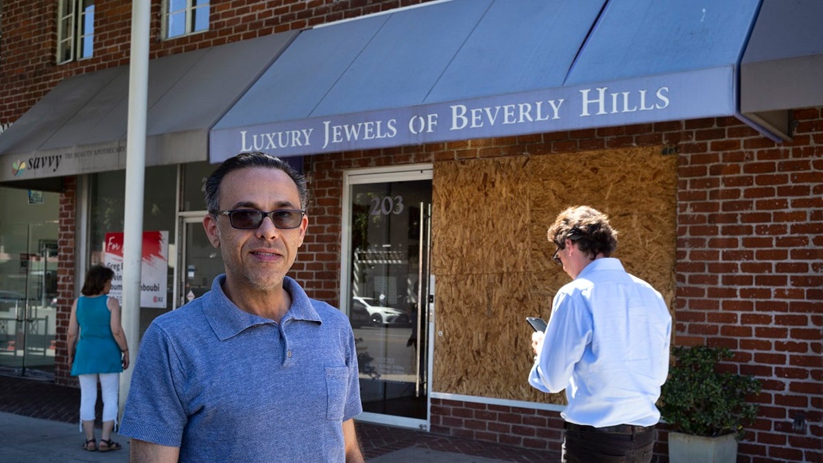 Owner Peter Sedghi stands on the street in front of his boarded up shop, Luxury Jewels of Beverly Hills in Beverly Hills, Calif. Sedghi said he was in his back office when he heard what sounded like gunshots during a brazen smash-and-grab robbery. 