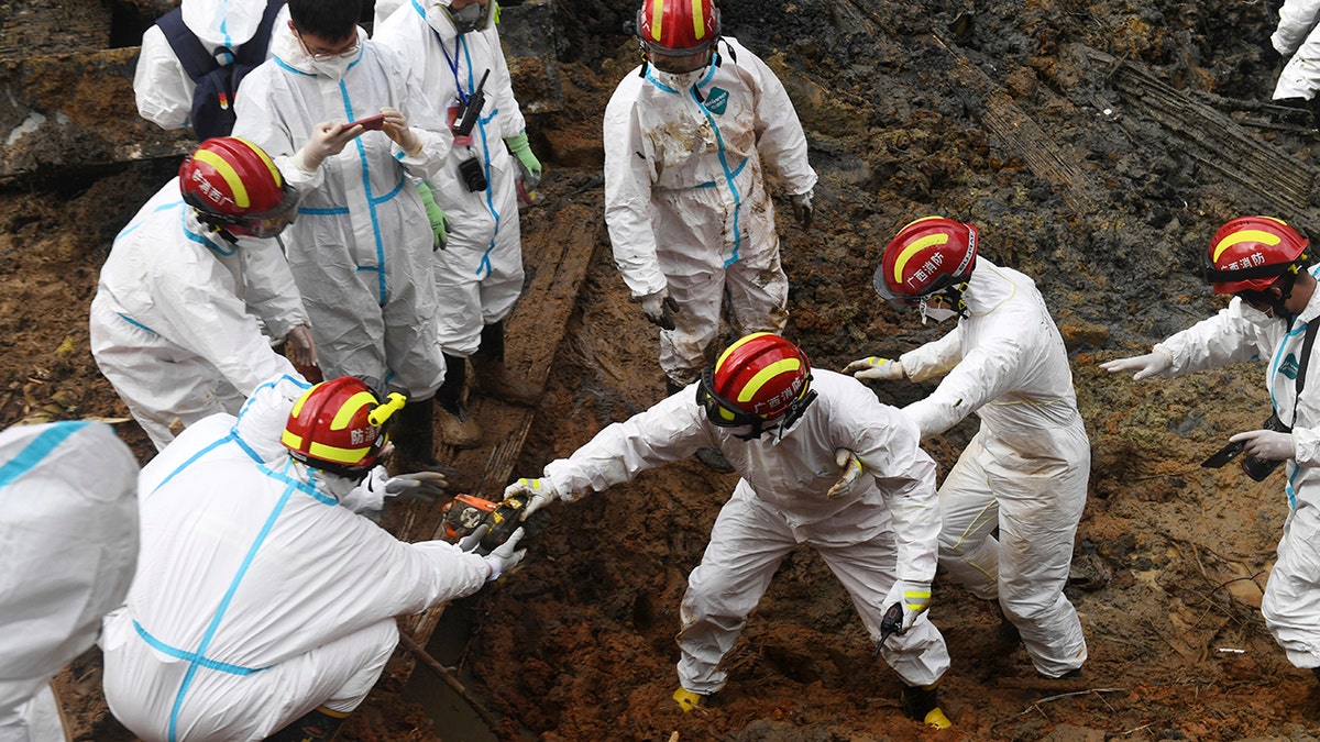 In this photo released by Xinhua News Agency, rescuers identify objects collected at the core site of Monday's plane crash in Tengxian County, southern China's Guangxi Zhuang Autonomous Region, Friday, March 25, 2022. (Lu Boan/Xinhua via AP)