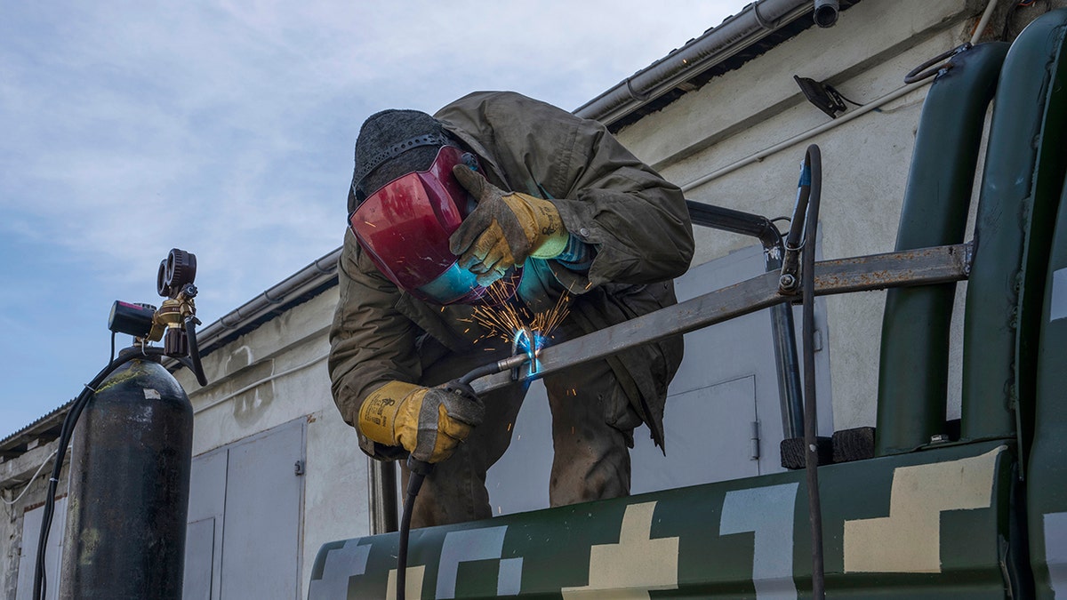 Car welder Ostap Datsenko, 31, works on a donated pickup truck so a volunteer can drive it to frontlines, at a welding workshop in Lviv, western Ukraine, Sunday, March 27, 2022.