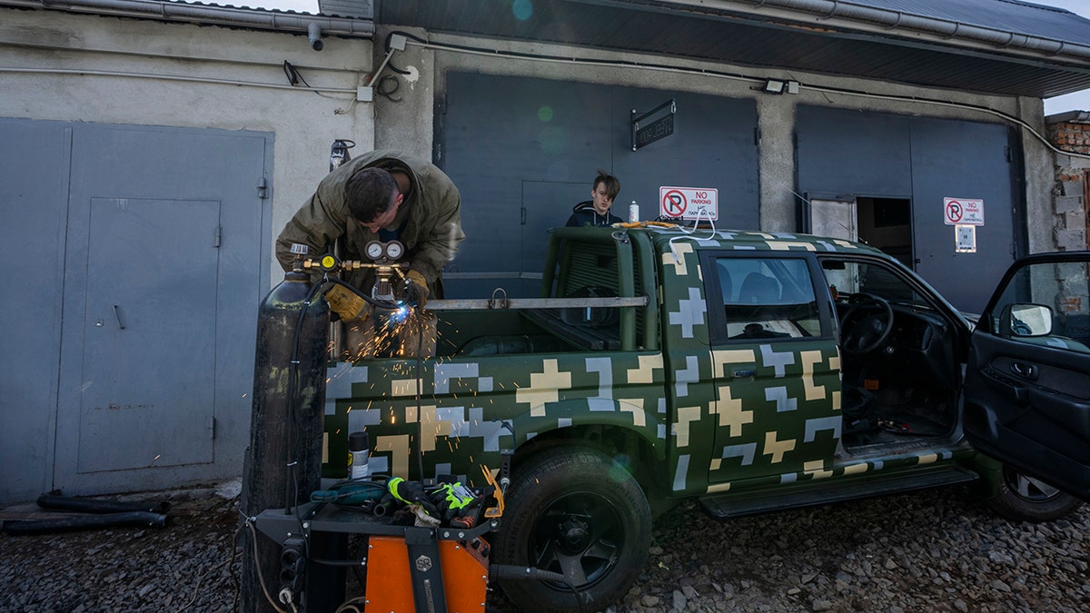 Car welder Ostap Datsenko, 31, works on a vehicle that will be sent to soldiers on the frontlines, at a welding workshop in Lviv, western Ukraine, Sunday, March 27, 2022.