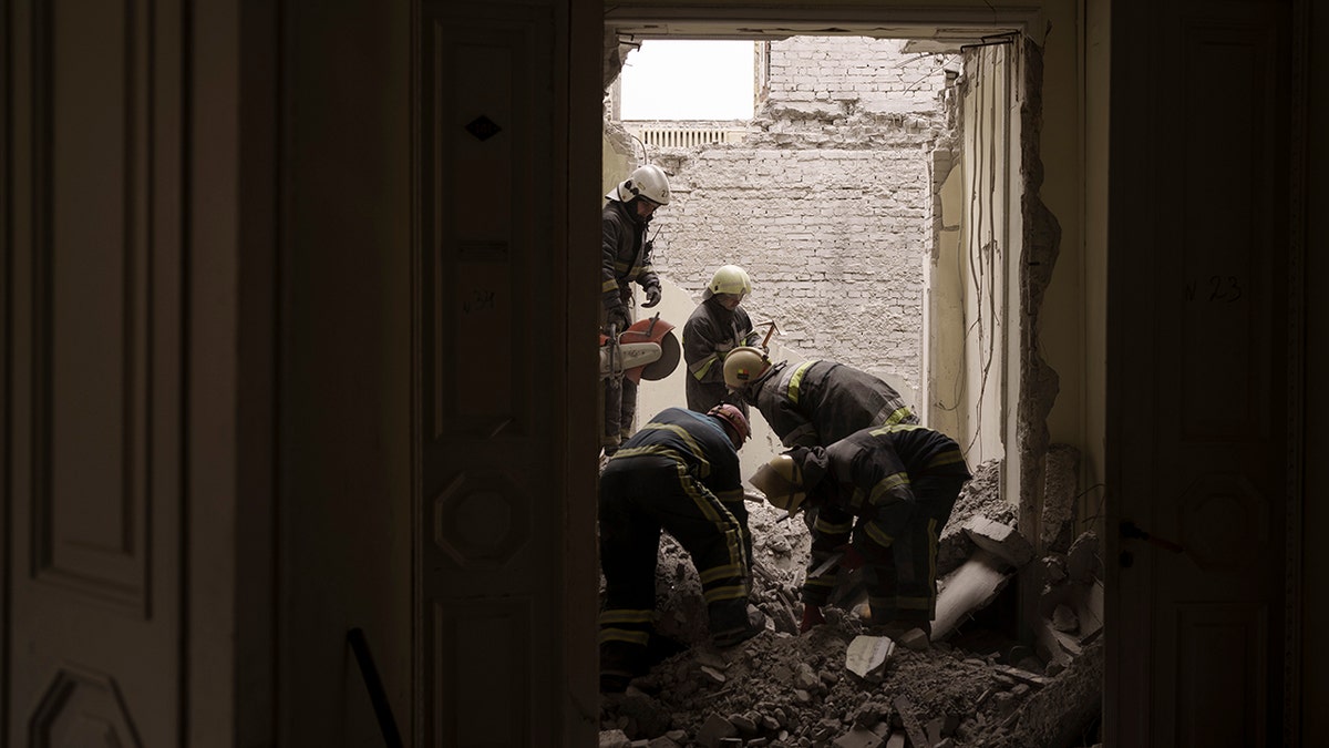 Emergency workers search for bodies under the debris of the regional administration building, heavily damaged after a Russian attack earlier this month in Kharkiv, Ukraine, Sunday, March 27, 2022. 