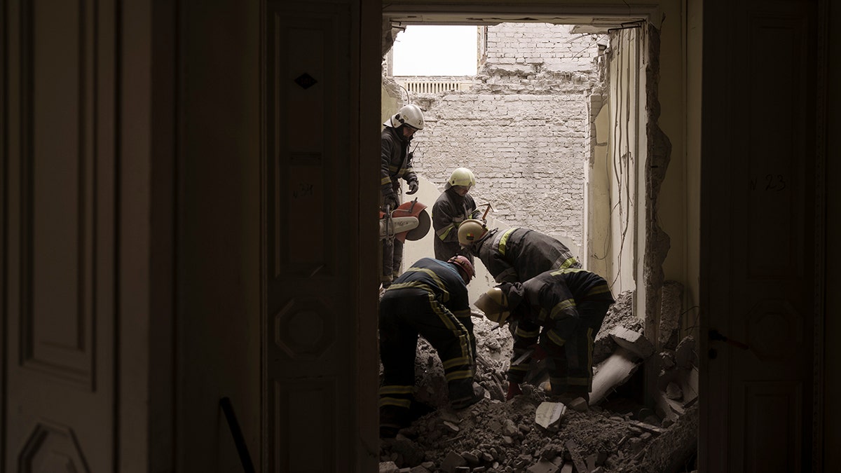 Emergency workers search for bodies under the debris of the regional administration building, heavily damaged after a Russian attack earlier this month in Kharkiv, Ukraine, Sunday, March 27, 2022.?