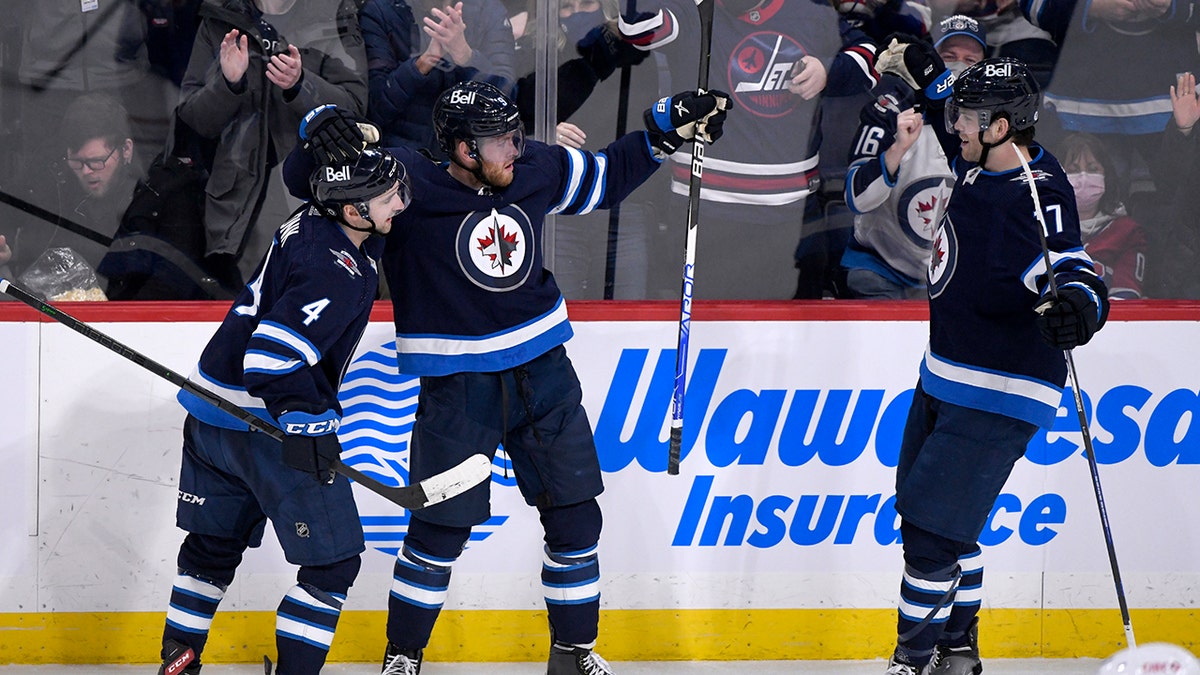 Winnipeg Jets' Andrew Copp celebrates his goal against the Montreal Canadiens with teammates Neal Poink (4) and Adam Lowry (17) during the second period of an NHL hockey game Tuesday, March 1, 2022, in Winnipeg, Manitoba.