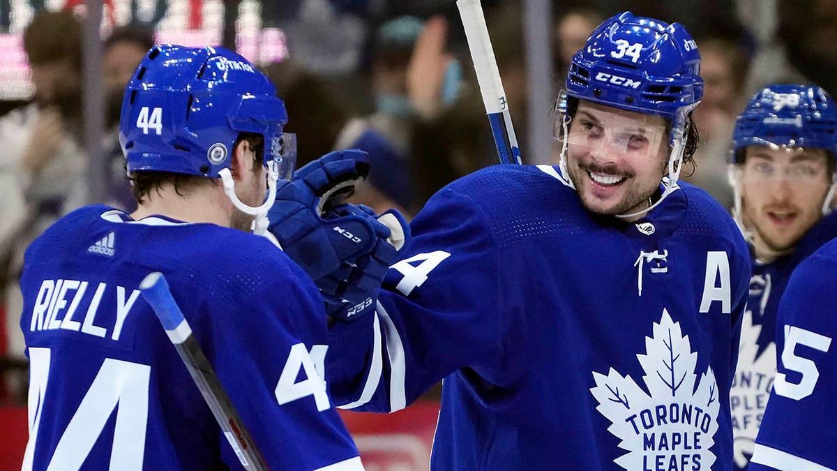 Toronto Maple Leafs forward Auston Matthews (34) celebrates his hat trick with teammate Morgan Rielly (44) during the third period of an NHL hockey game against the Seattle Kraken, Tuesday, March 8, 2022, in Toronto.