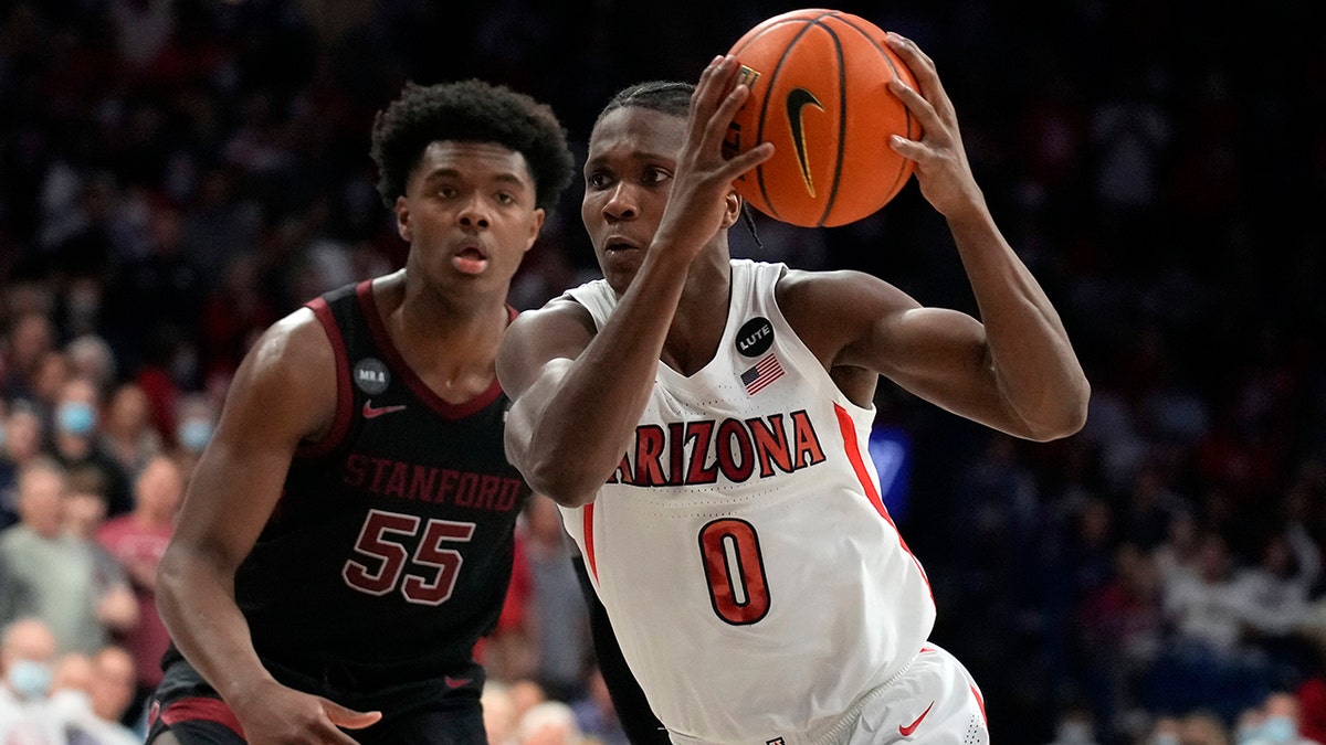 Arizona guard Bennedict Mathurin (0) drives past Stanford forward Harrison Ingram during the second half of an NCAA college basketball game Thursday, March 3, 2022, in Tucson, Ariz. Arizona won 81-69.