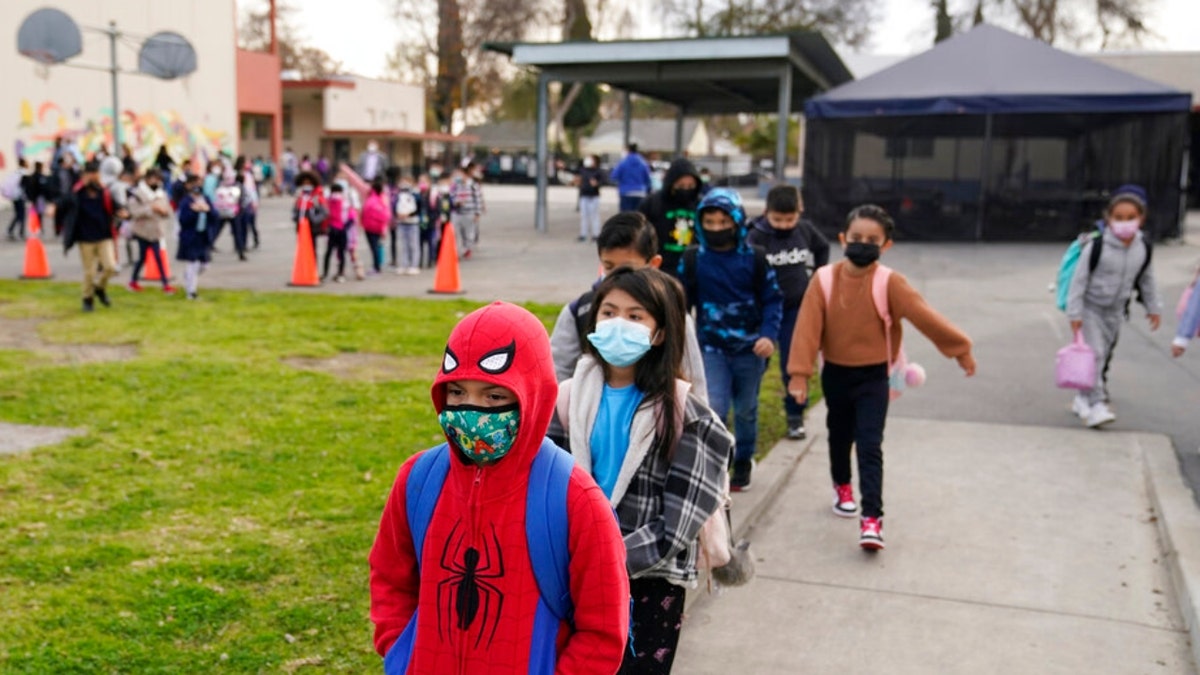 Students walk to class amid the COVID-19 pandemic at Washington Elementary School Jan. 12, 2022, in Lynwood, Calif.