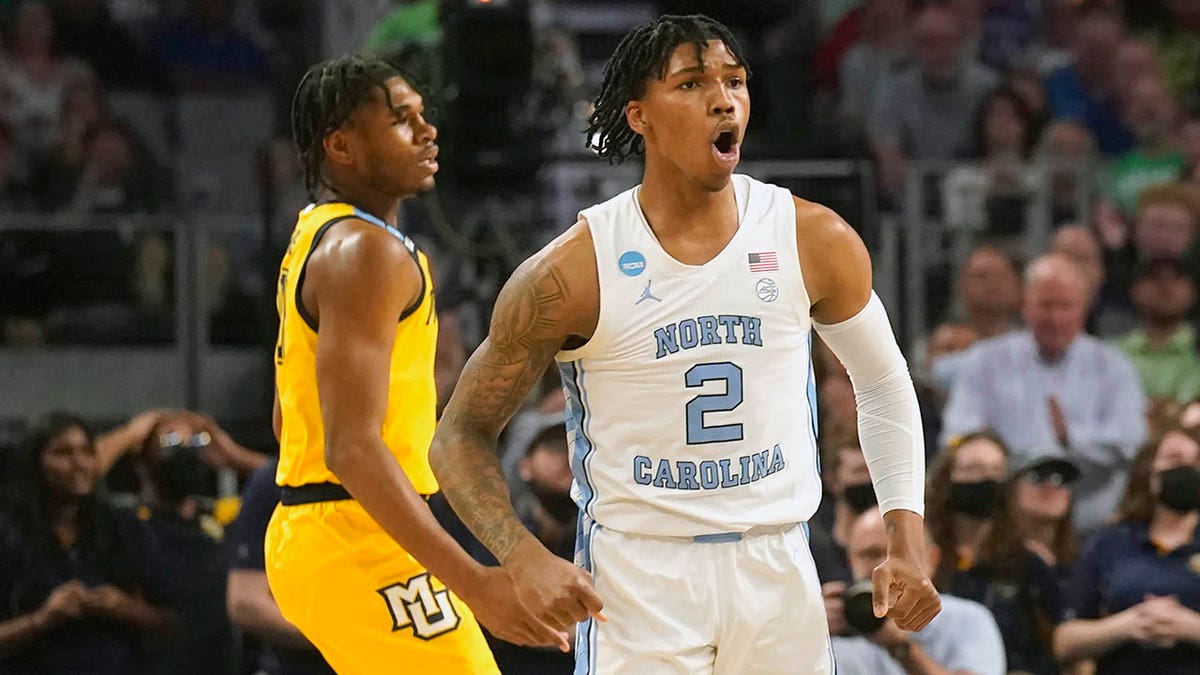 North Carolina guard Caleb Love (2) reacts to scoring, in front of Marquette forward Justin Lewis during the first half of a college basketball game in the first round of the NCAA men's tournament in Fort Worth, Texas, Thursday, March 17, 2022.