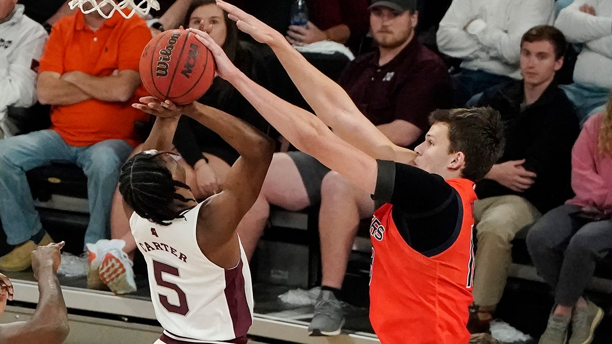 Mississippi State guard Cam Carter (5) is fouled by Auburn forward Walker Kessler (13) during the first half of an NCAA college basketball game in Starkville, Miss., Wednesday, March. 2, 2022. Auburn won in overtime 81-68.