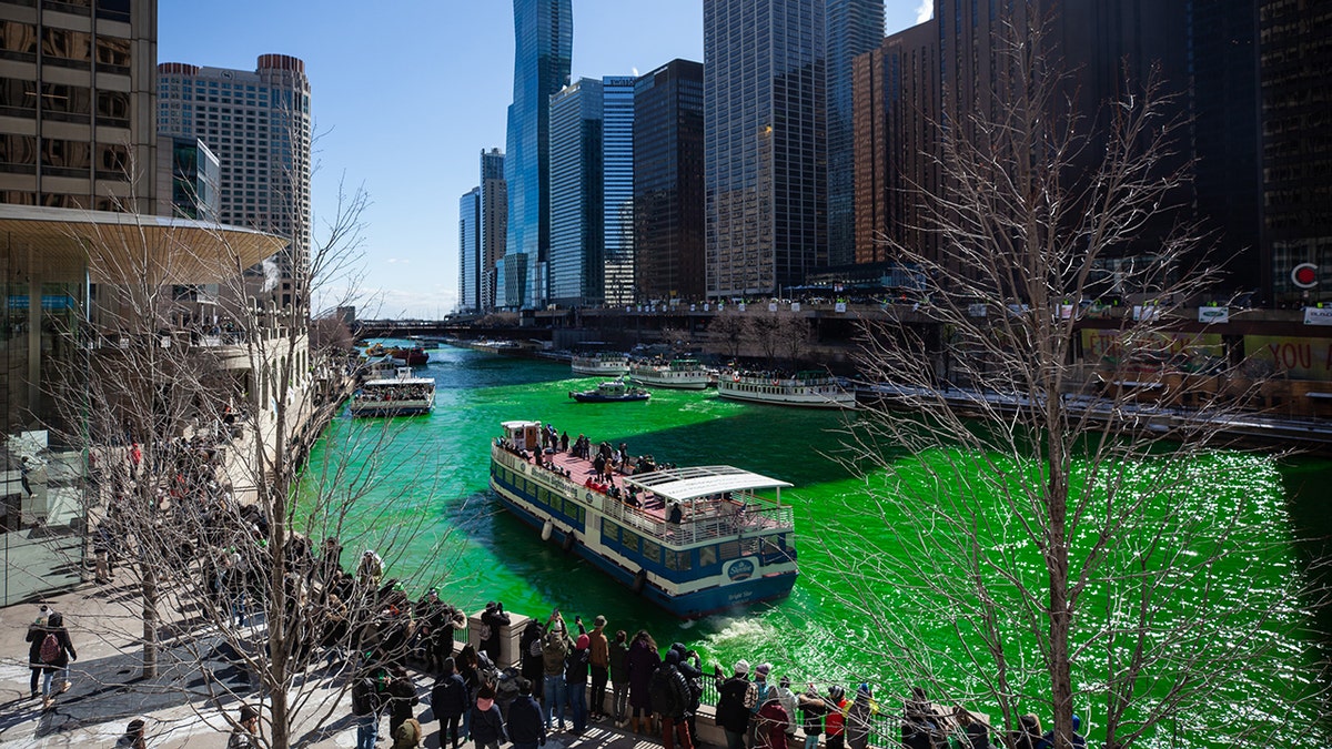 People gathered on the banks of the Chicago River while it was dyed green on Saturday, March 12, 2022.