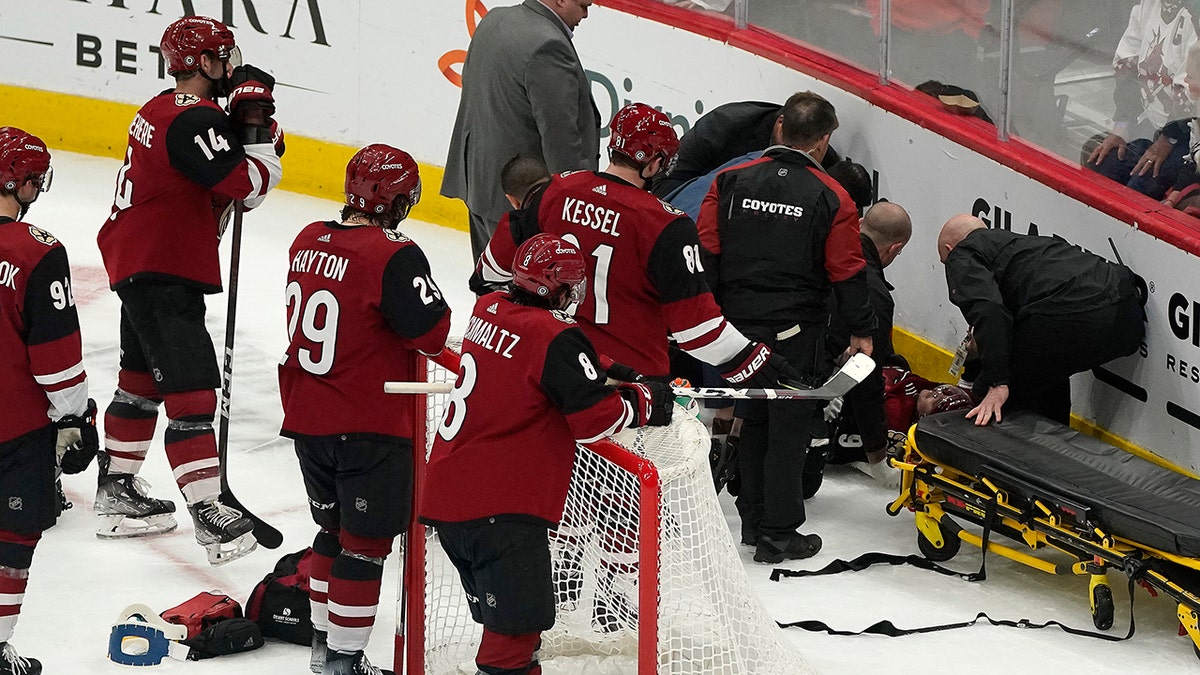 Arizona Coyotes watch as medical personnel and team officials attend to Clayton Keller, who crashed against the the boards during the third period of the team's NHL hockey game against the San Jose Sharks, Wednesday, March 30, 2022, in Glendale, Arizona.