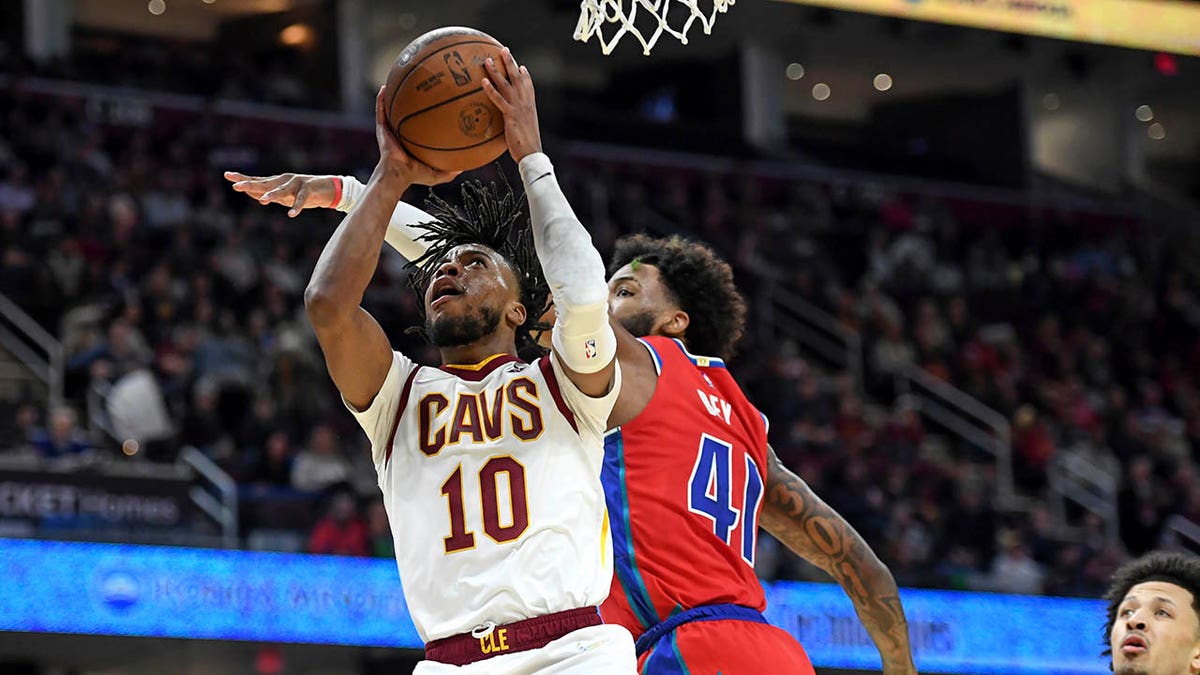Cleveland Cavaliers' Darius Garland (10) shoots next to Detroit Pistons' Saddiq Bey (41) during the first half of an NBA basketball game Saturday, March 19, 2022, in Cleveland. 