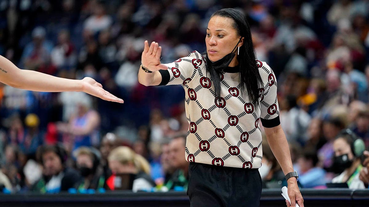 South Carolina head coach Dawn Staley congratulates a player during the second half of an NCAA college basketball semifinal round game against Mississippi at the women's Southeastern Conference tournament Saturday, March 5, 2022, in Nashville, Tenn. South Carolina won 61-51.