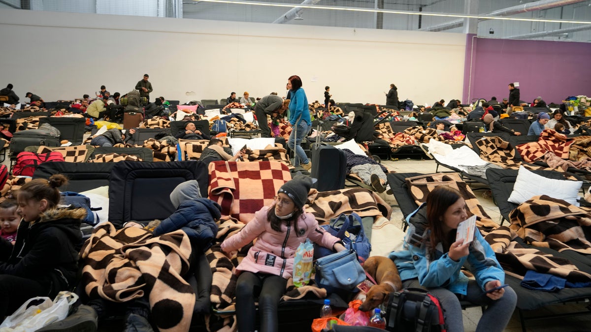 Displaced people rest at a makeshift shelter in Mlyny, near the Korczowa border crossing, in Poland.
