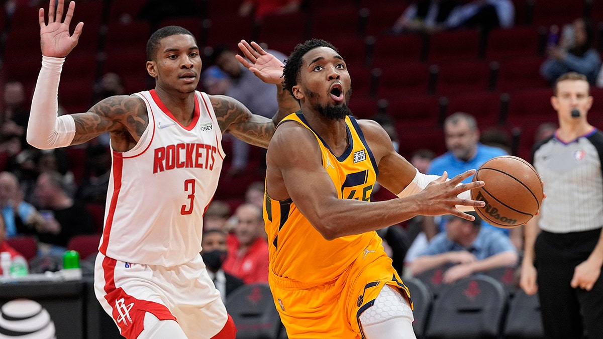 Utah Jazz's Donovan Mitchell (45) drives toward the basket as Houston Rockets' Kevin Porter Jr. (3) defends during the second half of an NBA basketball game Wednesday, March 2, 2022, in Houston. The Jazz won 132-127 in overtime.