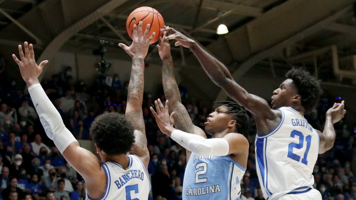 North Carolina guard Caleb Love (2) shoots against Duke forward Paolo Banchero (5) and forward AJ Griffin (21) during the first half of an NCAA college basketball game Saturday, March 5, 2022, in Durham, N.C. (Associated Press)