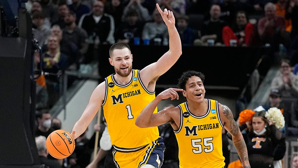 Michigan's Hunter Dickinson (1), and Eli Brooks (55) celebrate after they defeated Tennessee in a college basketball game in the second round of the NCAA tournament, Saturday, March 19, 2022, in Indianapolis.
