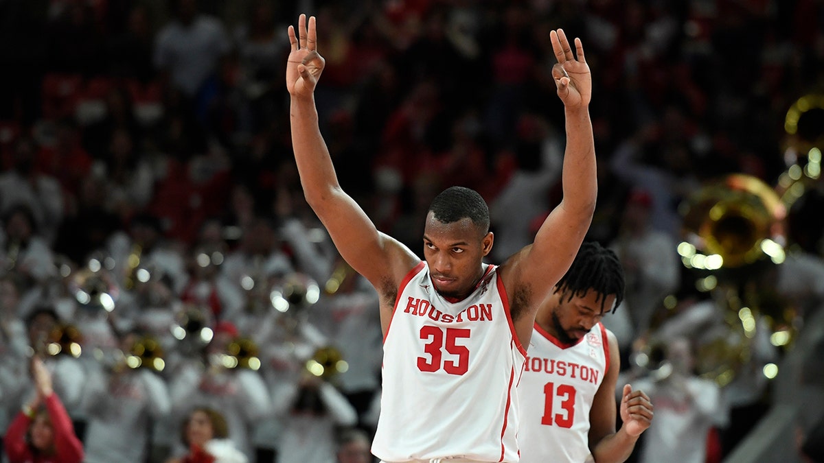 Houston forward Fabian White Jr. (35) celebrates a 3-point basket by guard Taze Moore against Cincinnati at the end of the first half of an NCAA college basketball game Tuesday, March 1, 2022, in Houston.