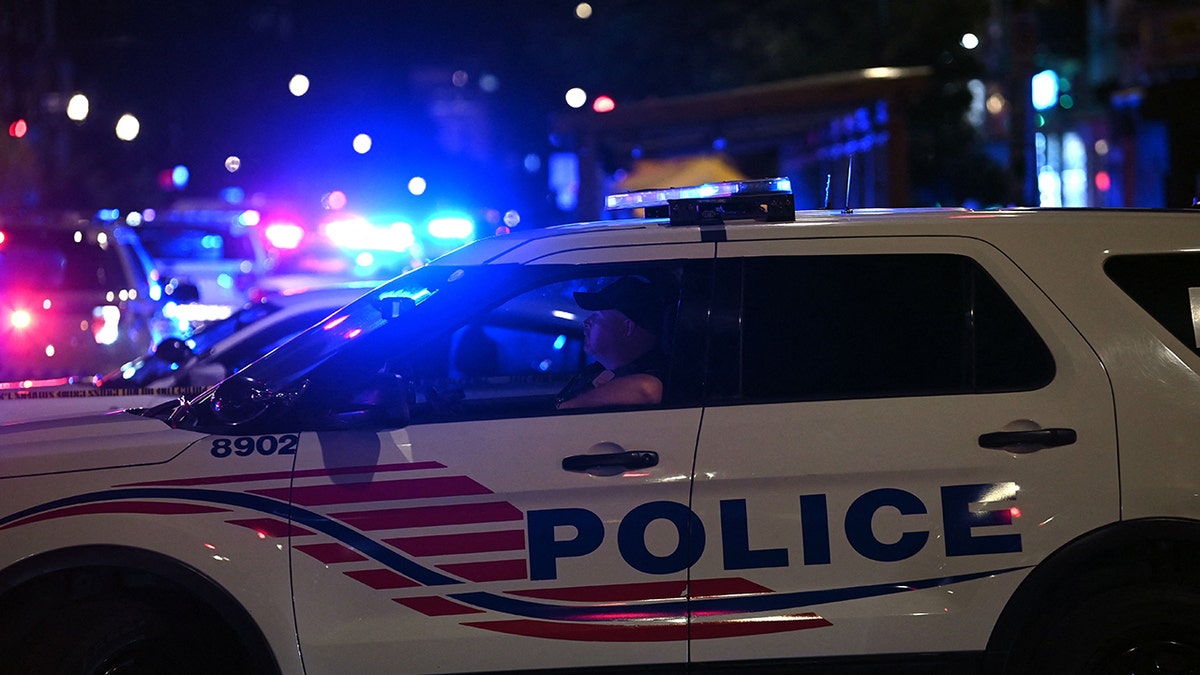 Police cars block a street after a shooting at a restaurant in Washington, DC, on July 22, 2021.