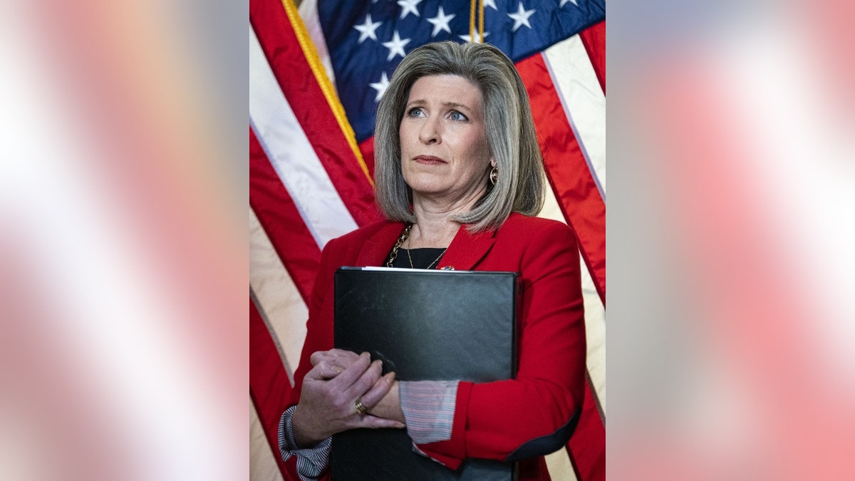 Congresswoman Joni Ernst holding binder